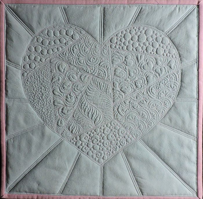 white quilt illustrating the types of machine quilting techniques Cindy teaches in her Fun Filler and Background Stitches workshop