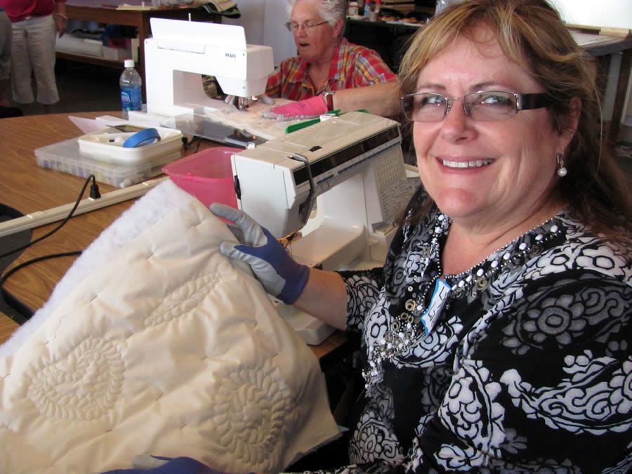 Smiling woman showing her Beginning Machine Quilting project